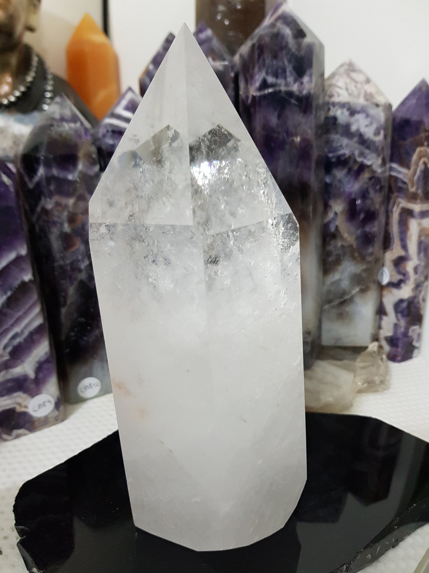 Clear Quartz crystal point tower polished standing specimen from Brazil with clear upper section and milky white base