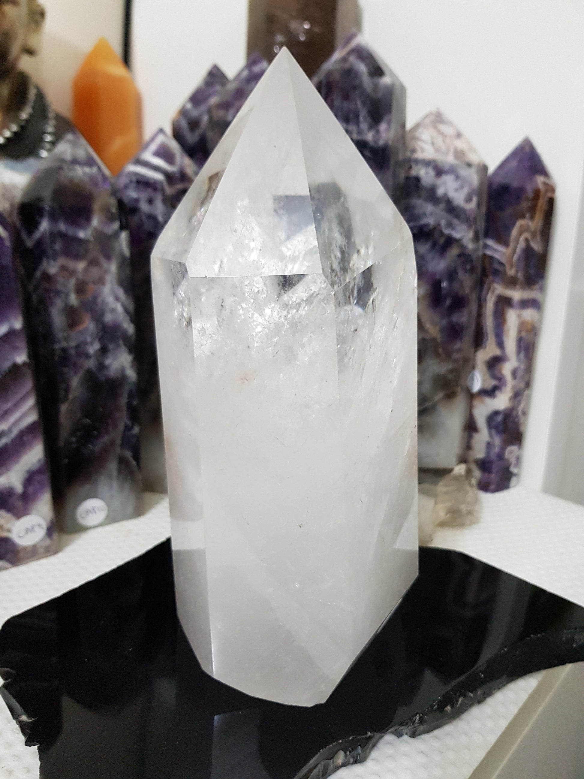 Clear Quartz crystal point tower polished standing specimen from Brazil with clear upper section and milky white base