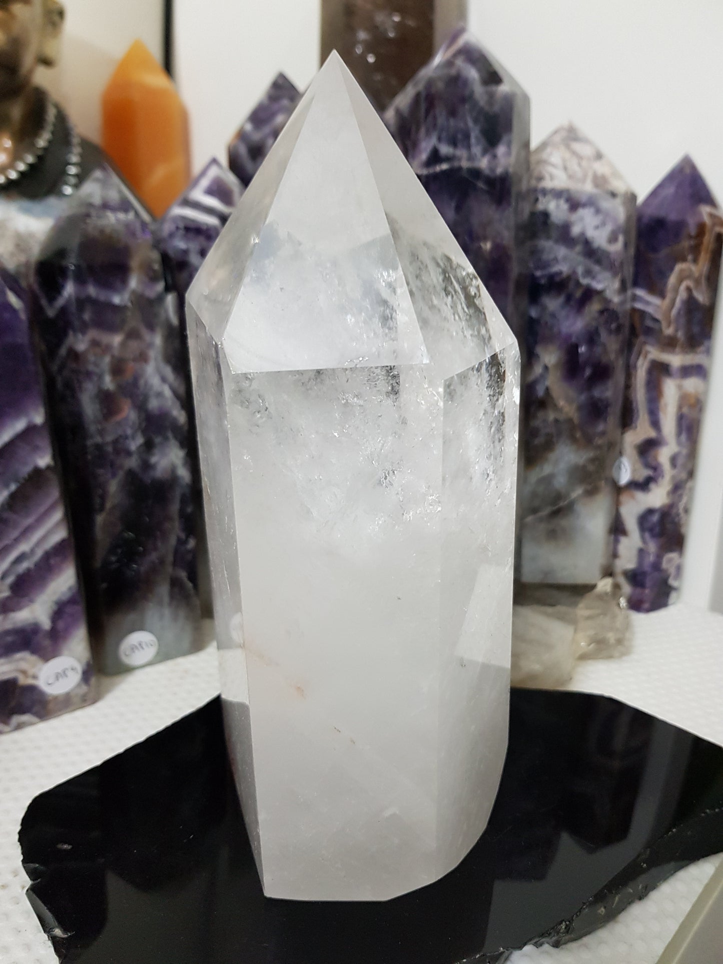 Clear Quartz crystal point tower polished standing specimen from Brazil with clear upper section and milky white base
