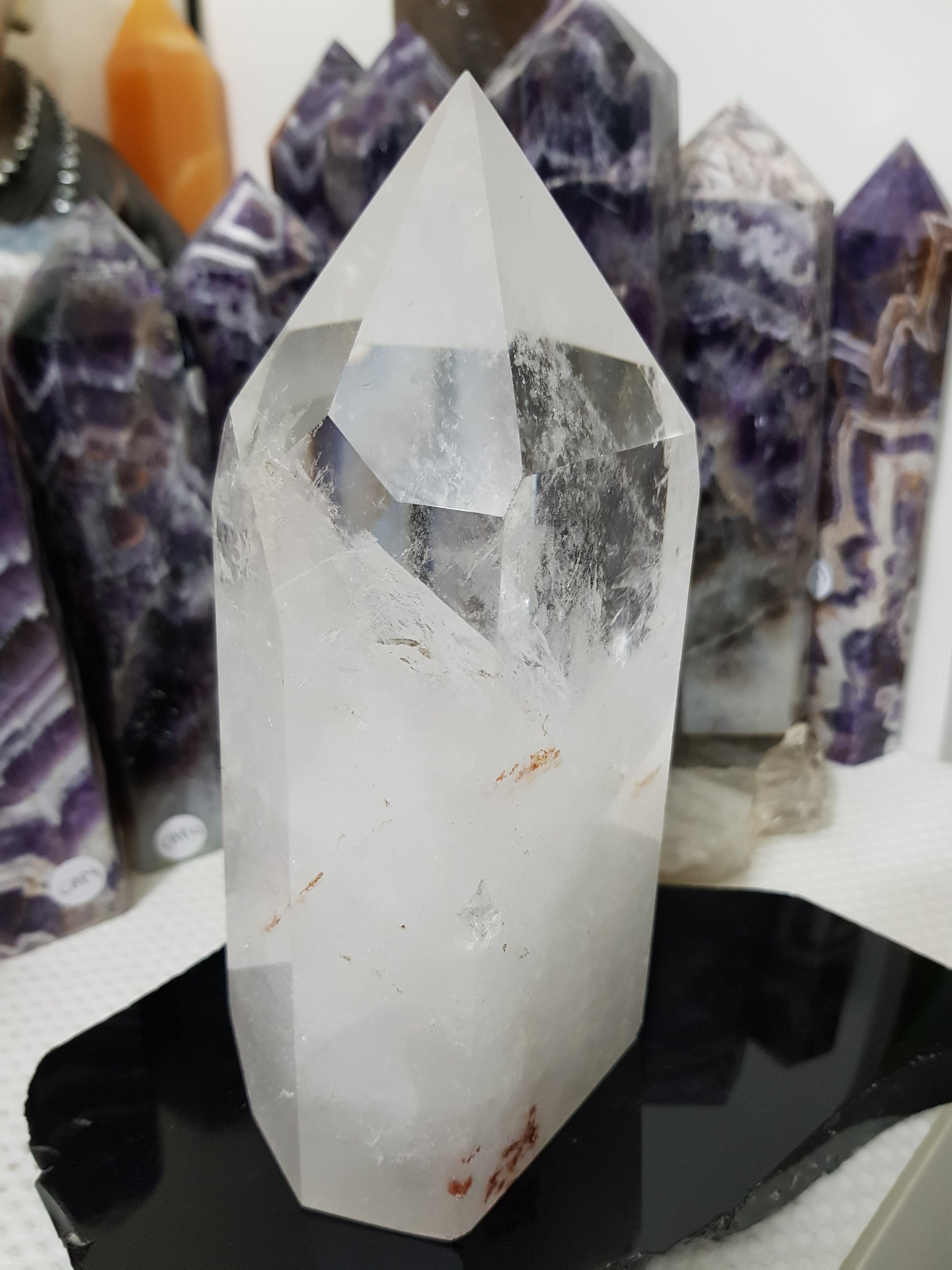 Clear Quartz crystal point tower polished standing specimen from Brazil with clear upper section and milky white base