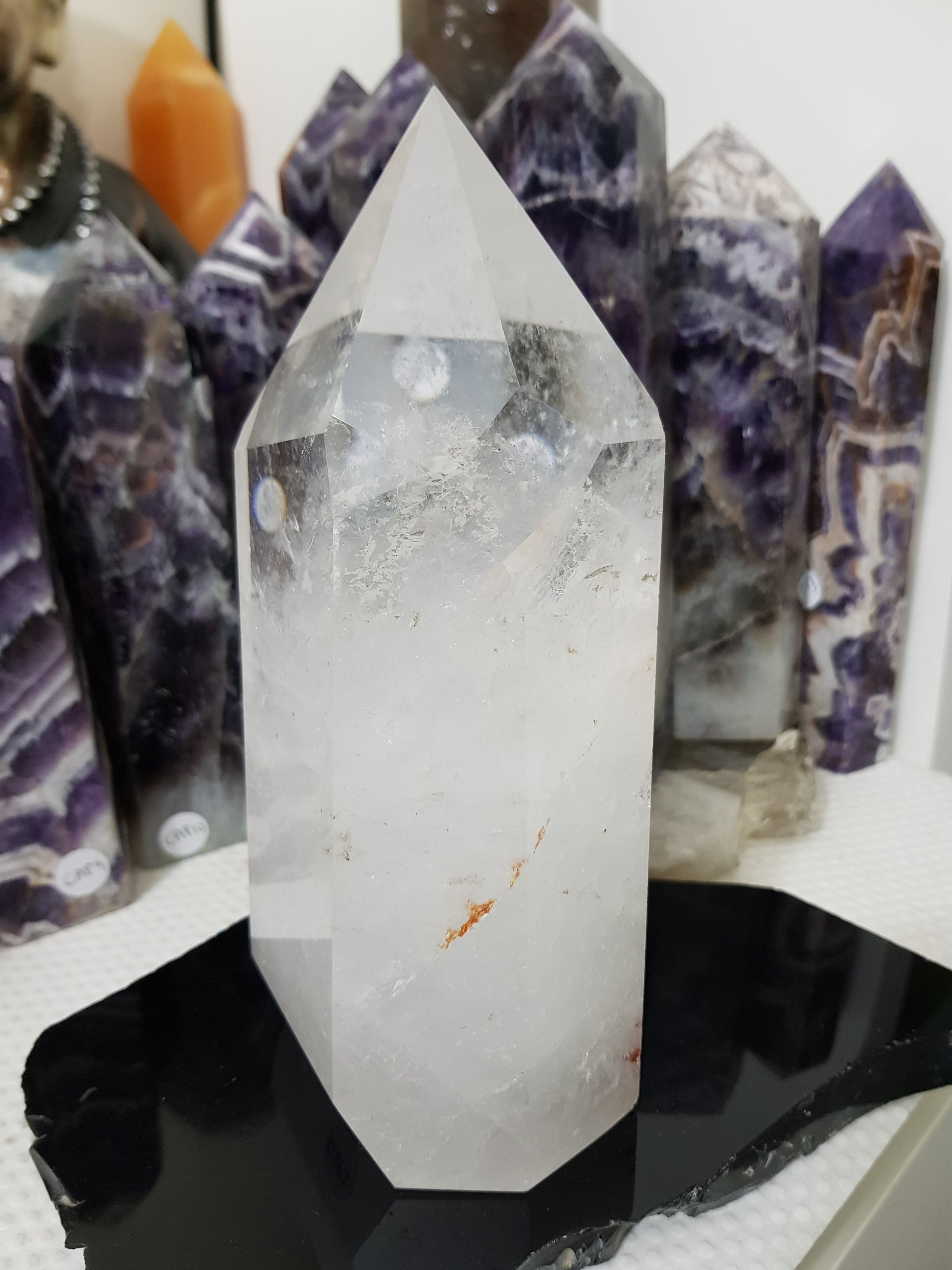 Clear Quartz crystal point tower polished standing specimen from Brazil with clear upper section and milky white base