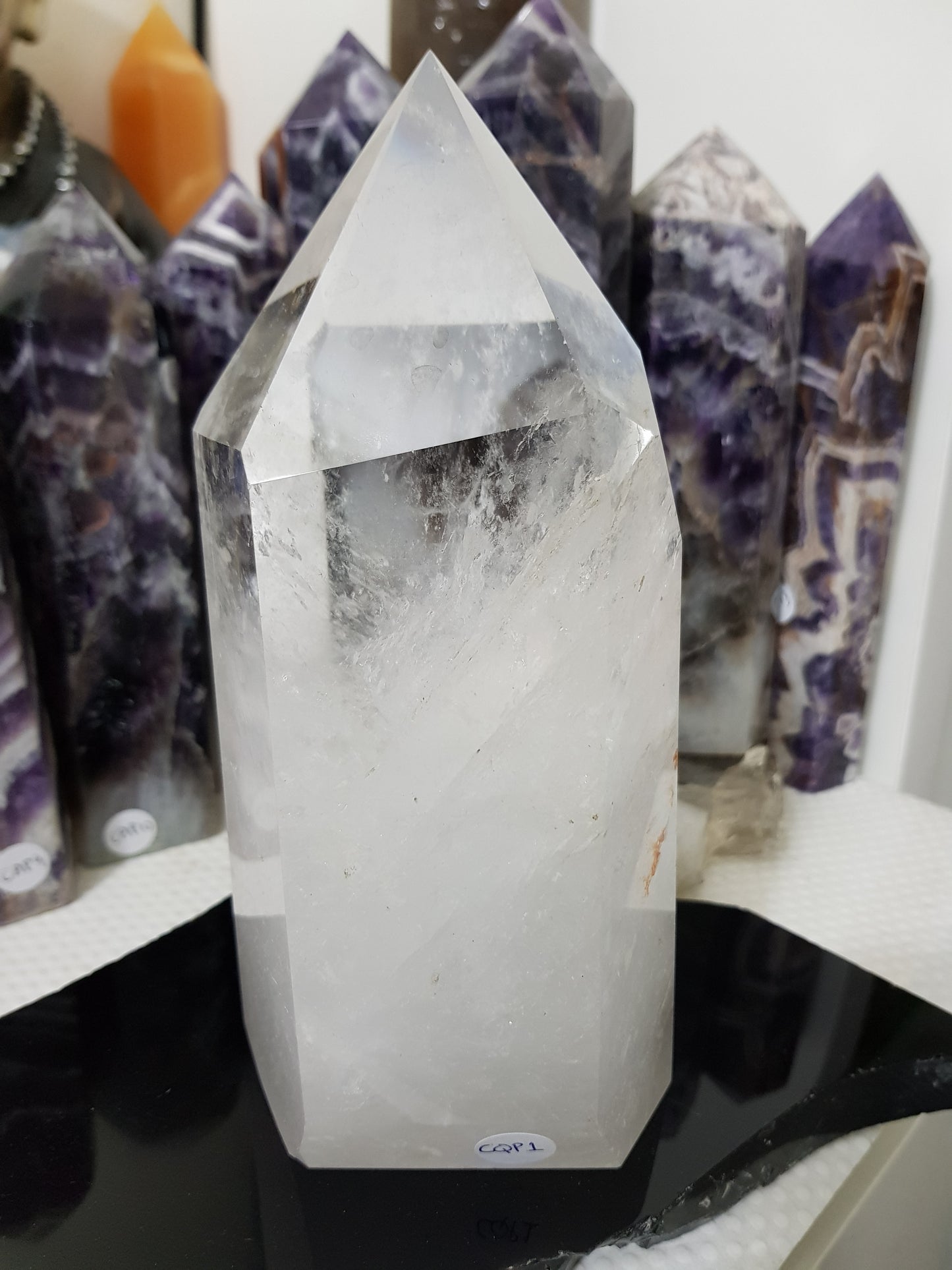 Clear Quartz crystal point tower polished standing specimen from Brazil with clear upper section and milky white base