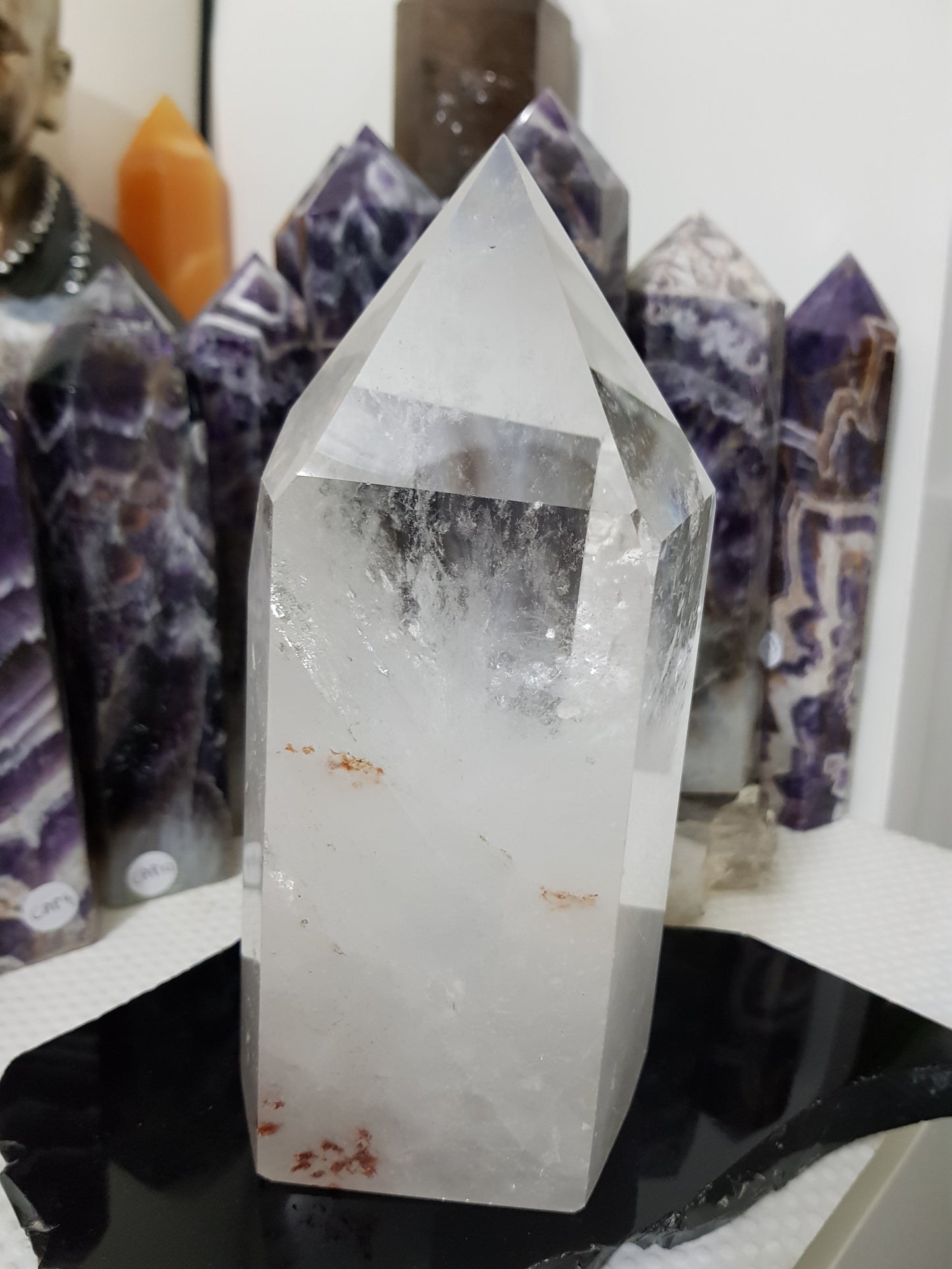 Clear Quartz crystal point tower polished standing specimen from Brazil with clear upper section and milky white base