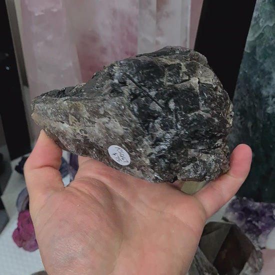 A hand holding a natural Smoky Quartz crystal chunk that is approximately 12.5 centimetres by 8.5 centimetres in size