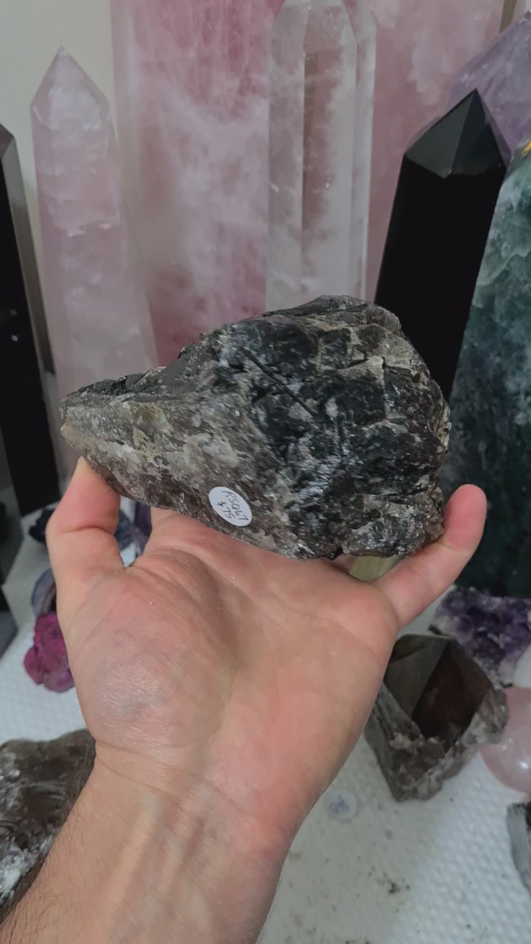 A hand holding a natural Smoky Quartz crystal chunk that is approximately 12.5 centimetres by 8.5 centimetres in size
