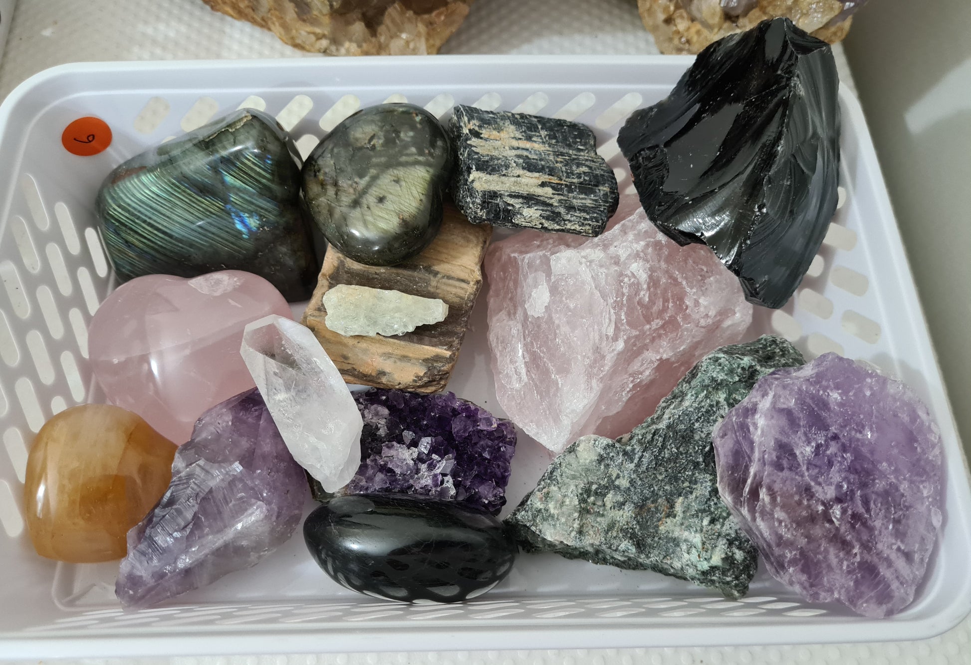 An assortment of mixed natural and polished crystals layed out on a table